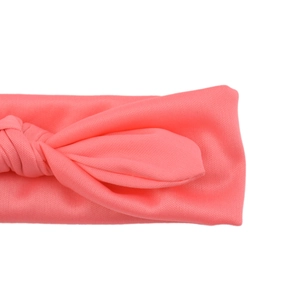 Close-up of pink knotted baby headband showing soft fabric texture and pleated bow detail