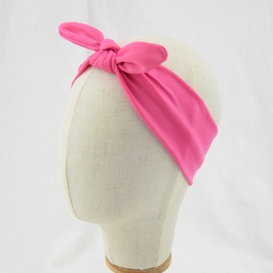 Detailed view of a soft pink knotted headband with rabbit ears for infants and kids