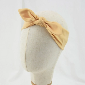 Close-up of baby knotted headband with soft rabbit ear bow on a model head display