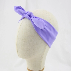Detail of a purple knotted fabric headband with rabbit ears on a neutral mannequin head