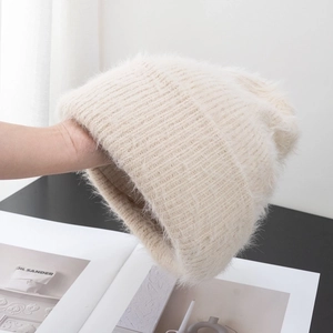 Detailed macro view of the fluffy off-white plush knit texture and thick ribbed weave