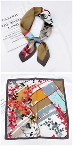 Détails du foulard carré en soie avec motifs floraux et géométriques sur un livre