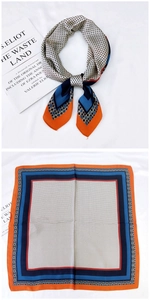 Détail du foulard en soie à pois géométriques avec bordure orange et rayures marine