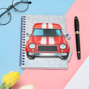 Close-up of spiral notebook featuring 3D red cartoon race car on a glittery silver cover