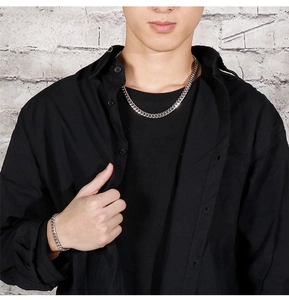 Detail of 8mm silver stainless steel Cuban link chain necklace and bracelet set on male model