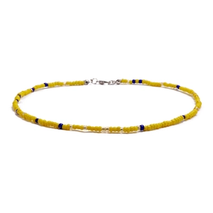 Detail showing handmade colorful seed bead necklace with yellow and blue patterns