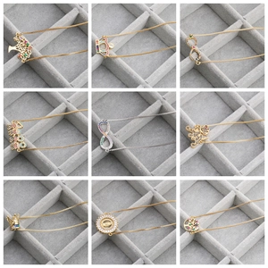 Collage of diverse metal charm bracelets with tree of life, crown, and leopard pendants