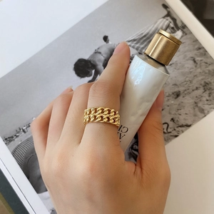 Close-up of golden double chain link ring on hand with a minimalist aesthetic style