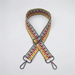 Detail of adjustable woven bag strap with colorful ethnic patterns and metal clasps