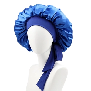 Detail of blue satin sleep cap featuring a wide adjustable tie band on a model