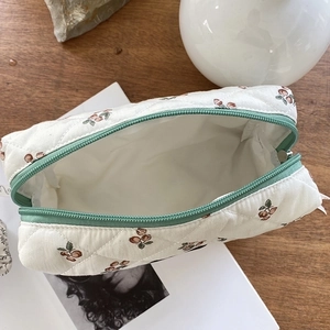 Portable floral quilted makeup bag with brown cherry pattern and green zipper for travel