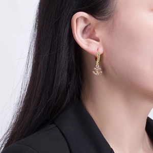 Golden anchor earrings with colorful crystals on female model for a stylish nautical look