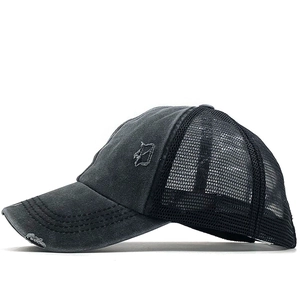 Detailed side view of distressed gray ponytail trucker hat with mesh back and embroidery
