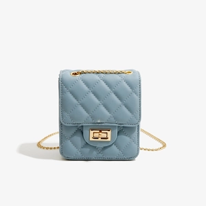 Detailed close-up of blue quilted PU leather bag with golden chain and twist lock