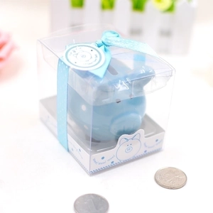 Blue ceramic piggy bank with white polka dots in a gift box with blue ribbon