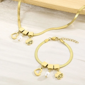 Detailed macro view of golden snake chain with heart charms and white pearl accents