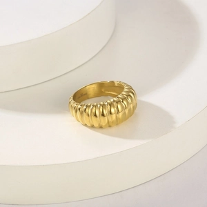 Detailed close-up of a gold-plated stainless steel ribbed ring on a minimalist pedestal