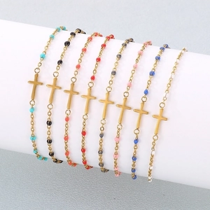 Detail shot of multi-colored beaded cross bracelet set on a white cylindrical display