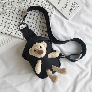 Détail du sac de poitrine en toile noire avec un ours en peluche et bandoulière réglable