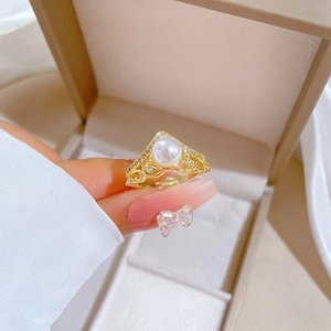 Adjustable gold crown ring with a pearl and sparkling zircons on a jewelry gift box