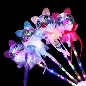 Close-up of four glowing cartoon pig fairy wands with LED lights and colorful bows