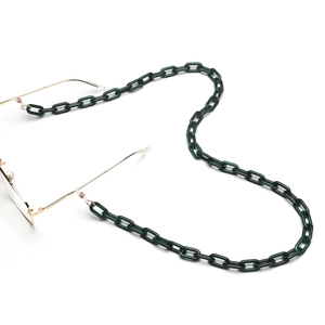 Dettaglio catena per occhiali in acrilico verde scuro con clip dorate e anelli in silicone