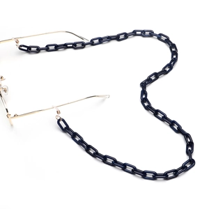 Dettaglio catena per occhiali in acrilico blu scuro con maglie dorate su sfondo bianco