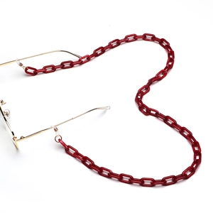 Dettaglio catena per occhiali in acrilico rosso a forma di cuore con clip in metallo dorato