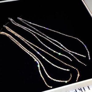 Elegant long rhinestone tassel earrings in gold and silver finish on black jewelry box