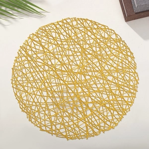 Close-up of a circular gold PVC cutout placemat with a shiny metallic woven texture