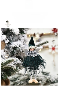Detail of dark green Christmas angel doll with lace collar and silver wings on snow branch