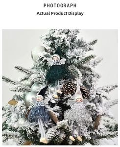 Detail of plush Christmas angel ornaments with sequin wings hanging on a snowy tree