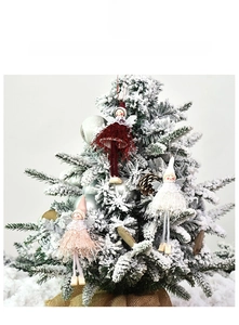 Detailed view of plush angel ornaments hanging on a snowy Christmas tree branch