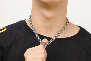 Close-up of a silver polished stainless steel O-chain necklace worn by a model