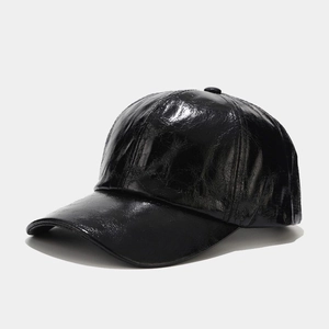 Detail of black glossy faux leather baseball cap showing high-shine finish and 6-panel structure