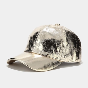 Macro detail of high-shine gold metallic PU leather with unique crinkled texture on cap