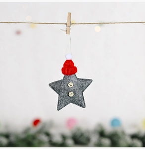 Detail of grey felt star ornament with a small red knit hat and wooden buttons