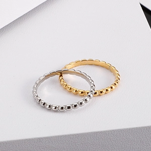 Minimalist beaded stackable rings in gold and silver finish on white background