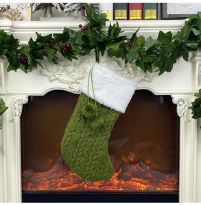 Détail d'une chaussette de Noël en tricot vert avec bordure en fausse fourrure blanche
