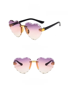 Detail of rimless heart-shaped children sunglasses with gradient purple lenses and gold bridge