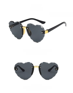 Detail view of heart-shaped rimless sunglasses with grey lenses and wavy edges