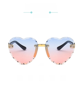 Close-up of heart-shaped rimless sunglasses with gradient lenses and gold metal bridge
