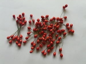 Makro-Detail von künstlichen roten Beeren mit Drahtstielen für Weihnachts-DIY