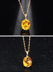 Detailed macro of an 18K gold-plated oval yellow citrine pendant with zircon accents