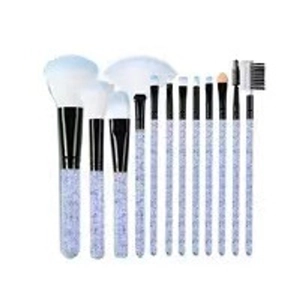 Detail of 12-piece makeup brush set featuring light purple glitter handles and blue bristles