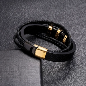 Detail of multi-layer black leather bracelet featuring two-tone magnetic stainless steel clasp
