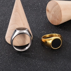 Detail of polished silver and gold signet rings with black oval inlay on wood props