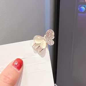 Detail of a golden butterfly hair claw clip with white opal and sparkly rhinestones