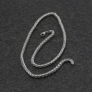 Polished silver stainless steel wheat chain necklace with lobster clasp on dark background