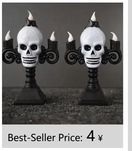 Detail of two Halloween LED skull candle holders with white flame bulbs and black bases